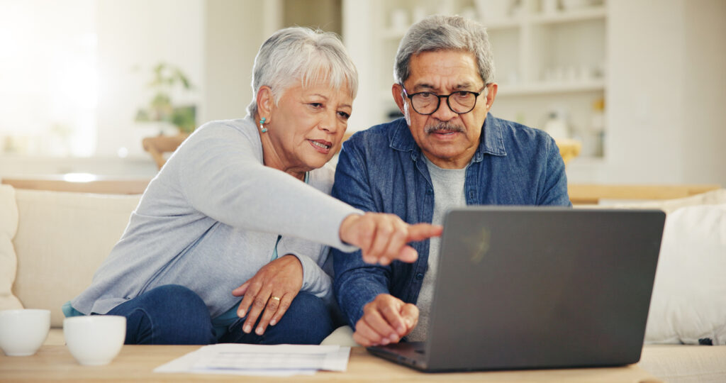 Older couple shopping for a furnace online on a laptop